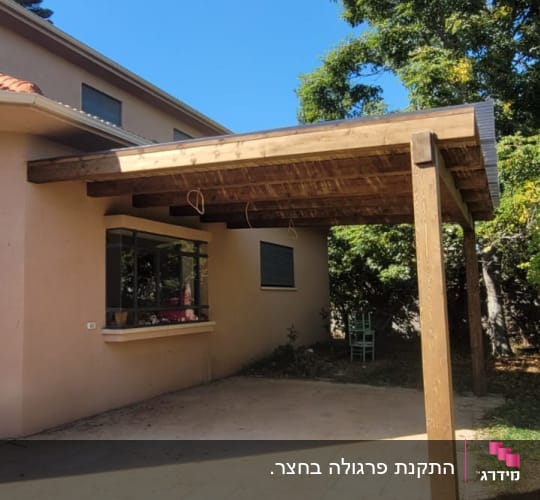 פרגולה מעץ בחצר ליד בית